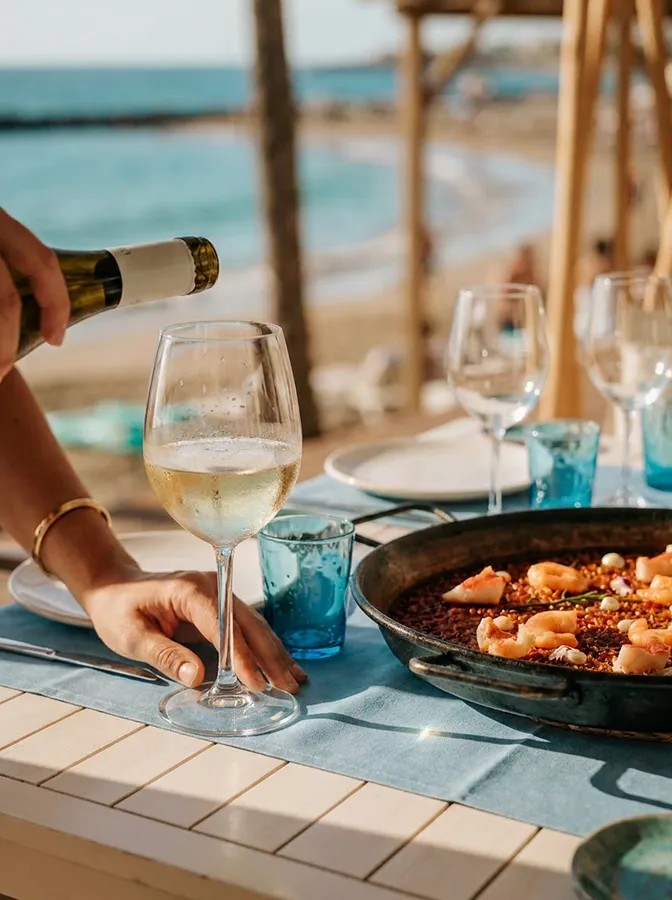 Glass of chilled white wine beside soupy lobster rice on the terrace at Bésame Mucho, Costa Adeje