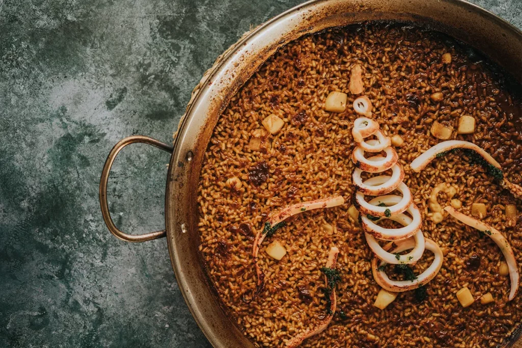 Arroz especial de la casa con potas y calamar en paellera, plato de Bésame Mucho en Costa Adeje, Tenerife
