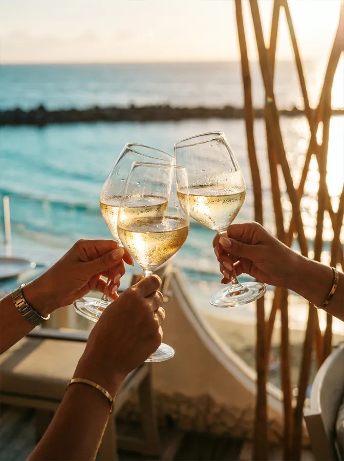 Brindis con copas de vino blanco en la terraza frente al mar de Bésame Mucho, Costa Adeje