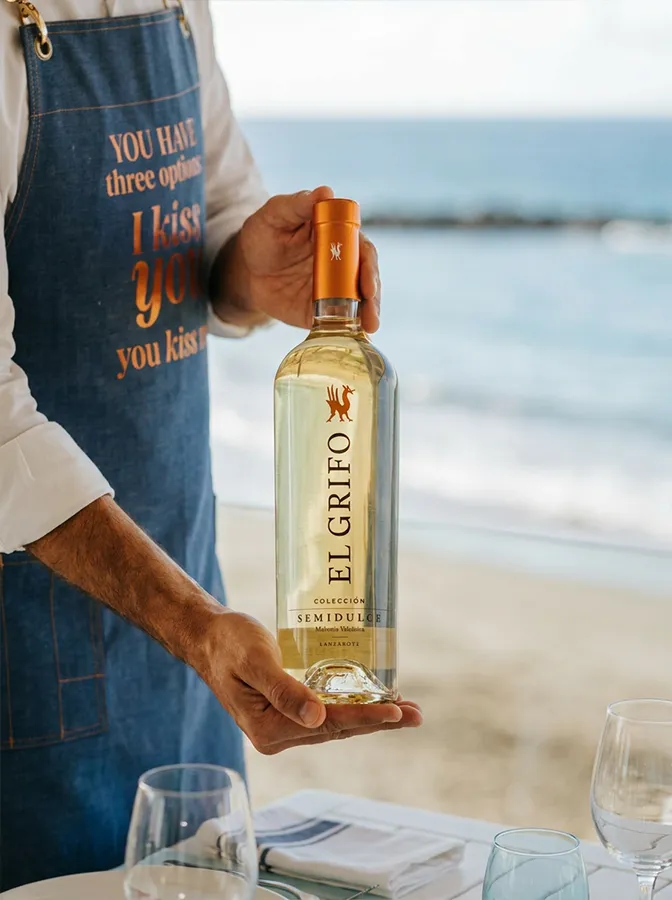 Botella de El Grifo Semidulce, malvasía volcánica de Lanzarote, frente al mar en Bésame Mucho