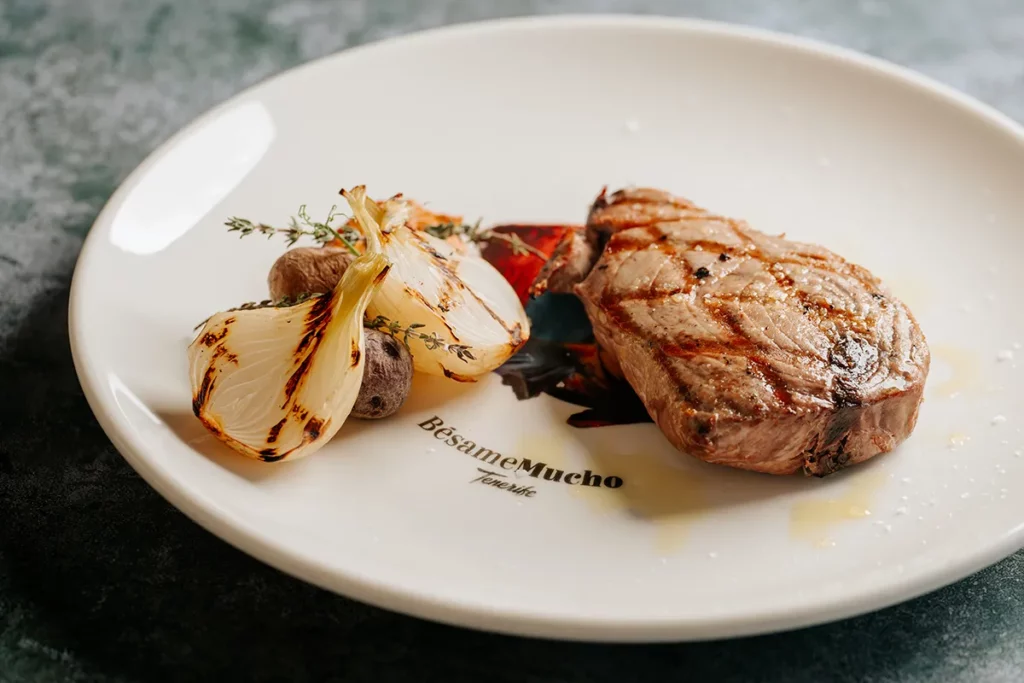 Solomillo de atún fresco a la brasa con cebolleta asada y salsa romesco