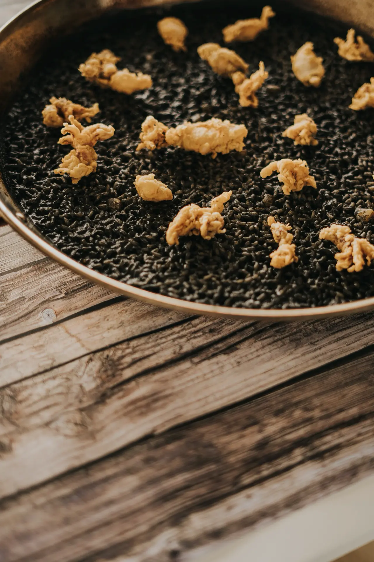 Detalle de chopitos fritos sobre arroz negro en Bésame Mucho, Costa Adeje, Tenerife